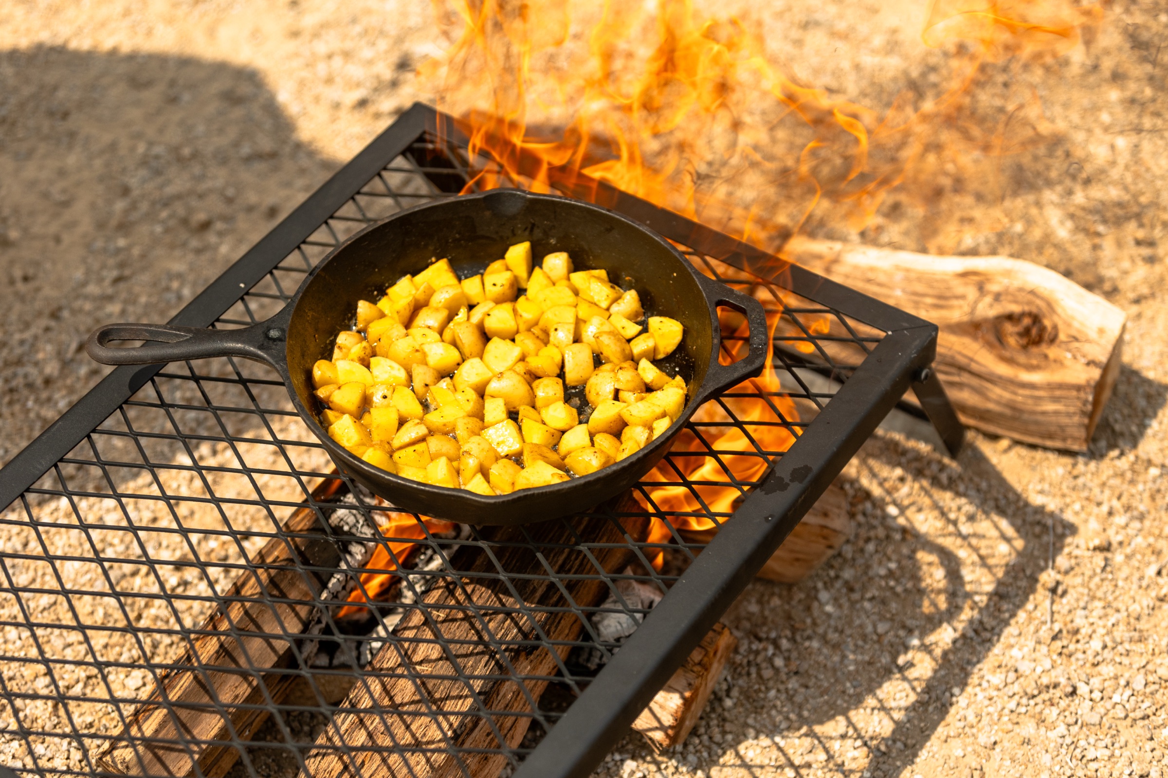 A cast iron skillet over an open campfire